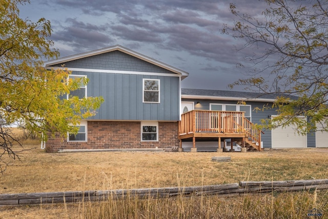 rear view of house with a lawn and a wooden deck