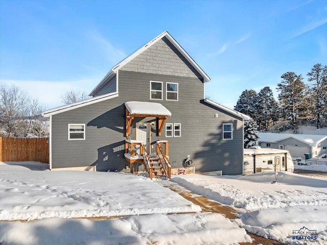 view of snow covered back of property