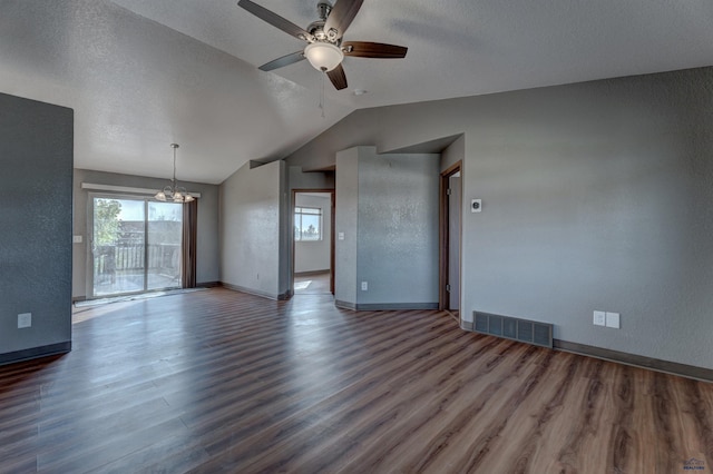 unfurnished living room with a textured ceiling, ceiling fan with notable chandelier, lofted ceiling, and dark wood-type flooring