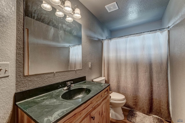 bathroom with vanity, hardwood / wood-style floors, a textured ceiling, and toilet