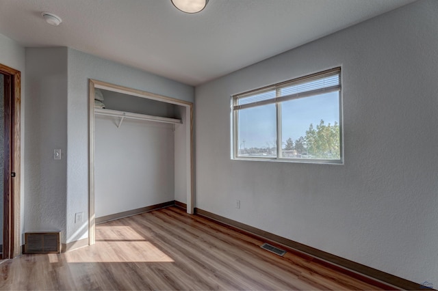 unfurnished bedroom featuring light wood-type flooring and a closet