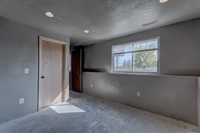 unfurnished bedroom with concrete flooring and a textured ceiling