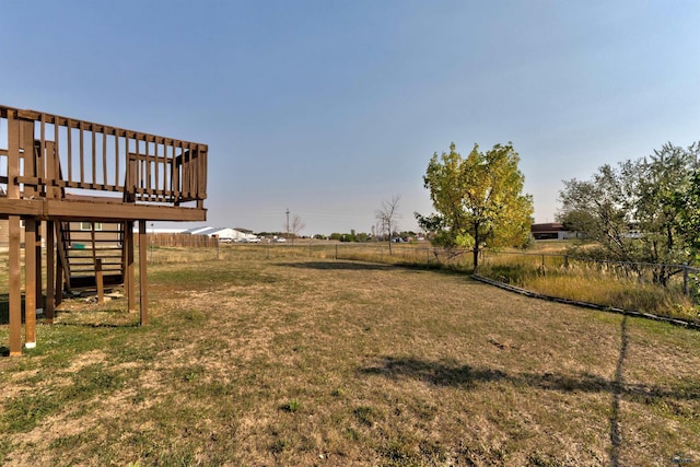 view of yard featuring a wooden deck and a rural view