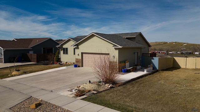 exterior space with a mountain view, a front yard, and a garage