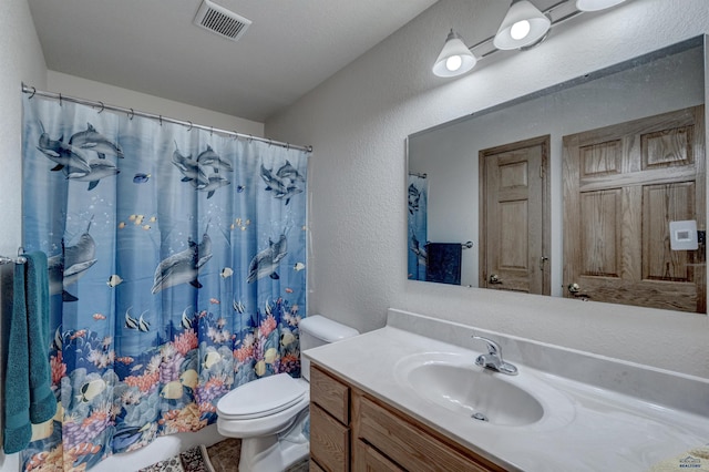 bathroom with curtained shower, vanity, and toilet