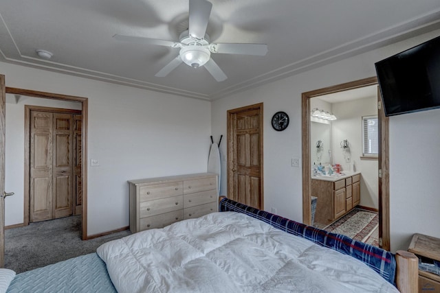 carpeted bedroom with ensuite bathroom and ceiling fan