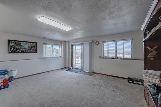 interior space with light carpet and a textured ceiling