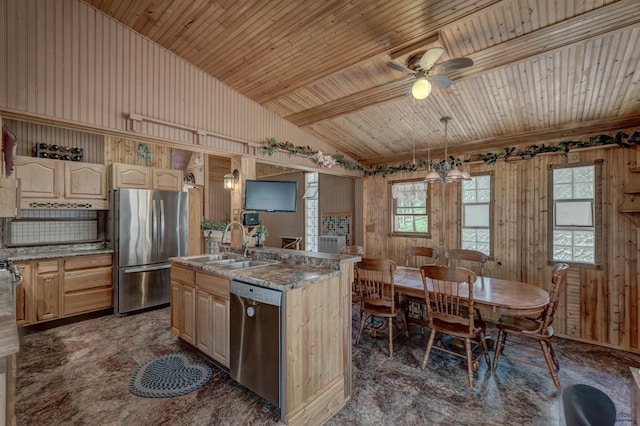 kitchen with ceiling fan, light brown cabinets, hanging light fixtures, stainless steel appliances, and an island with sink