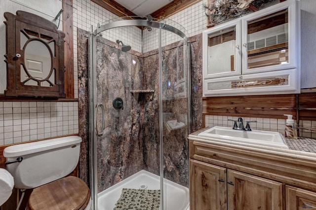 bathroom with backsplash, vanity, a shower with shower door, and toilet