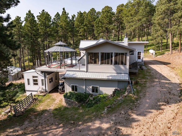 back of house with a gazebo and a sunroom