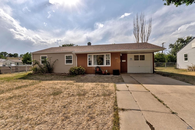 ranch-style house featuring a garage and a front lawn