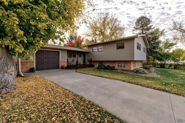 tri-level home featuring a garage and a front lawn