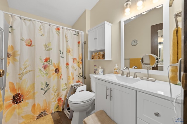 bathroom featuring hardwood / wood-style floors, vanity, lofted ceiling, and toilet