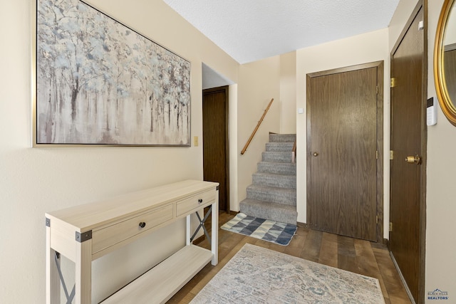 entrance foyer with a textured ceiling and dark hardwood / wood-style floors