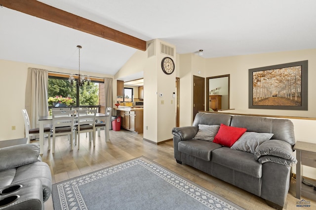 living room with lofted ceiling with beams, light hardwood / wood-style flooring, and a notable chandelier