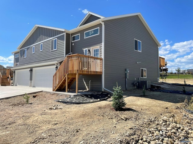 rear view of house featuring a garage and central AC unit