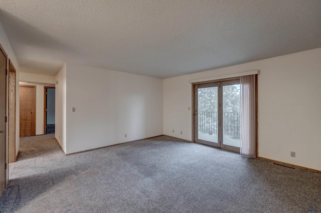 empty room with light colored carpet and a textured ceiling