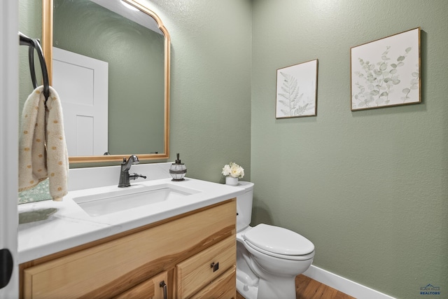 bathroom with vanity, toilet, and wood-type flooring