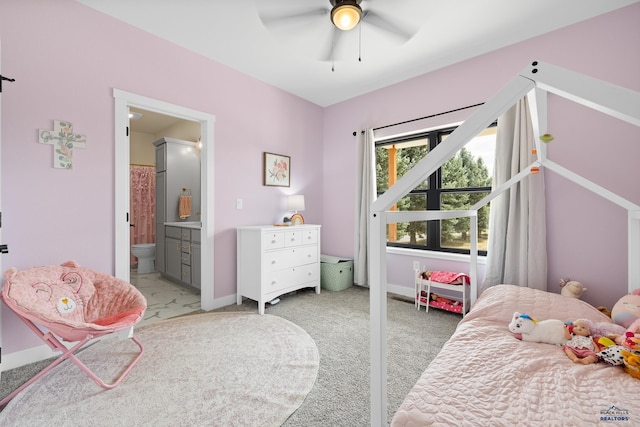 carpeted bedroom featuring ensuite bath and ceiling fan