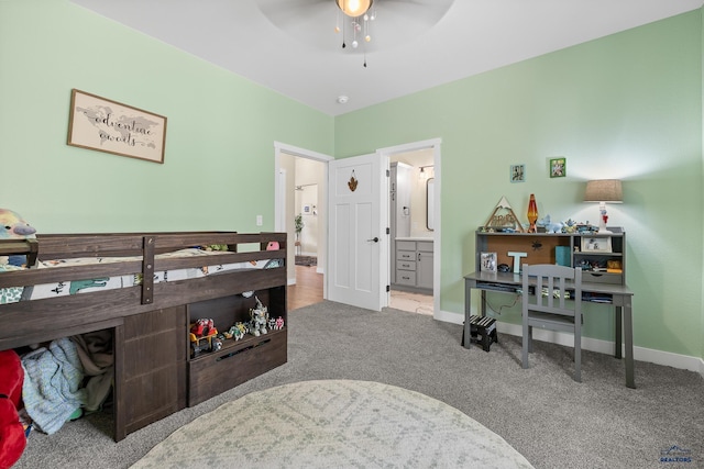 carpeted bedroom with ensuite bath and ceiling fan