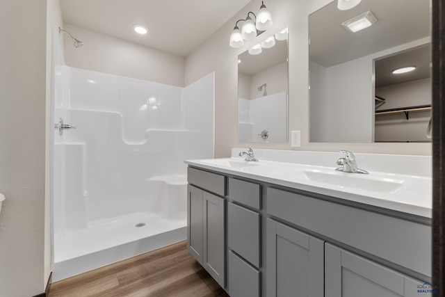 bathroom featuring vanity, wood-type flooring, and walk in shower