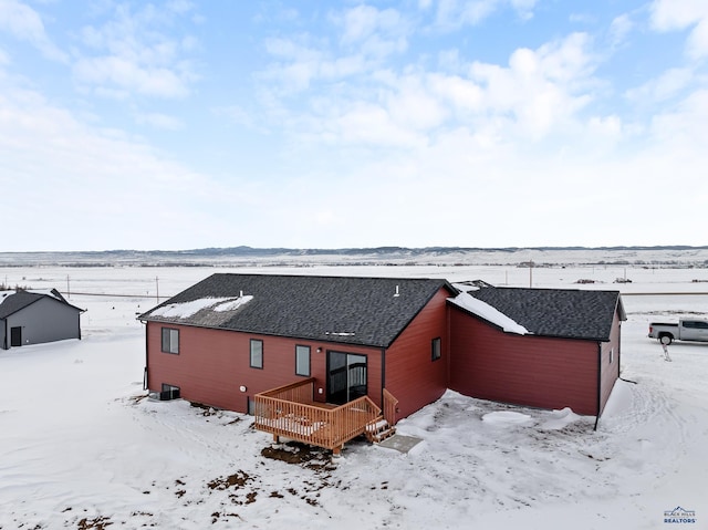 snow covered house with a deck