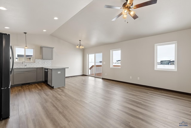 kitchen featuring gray cabinets, decorative backsplash, stainless steel appliances, and decorative light fixtures