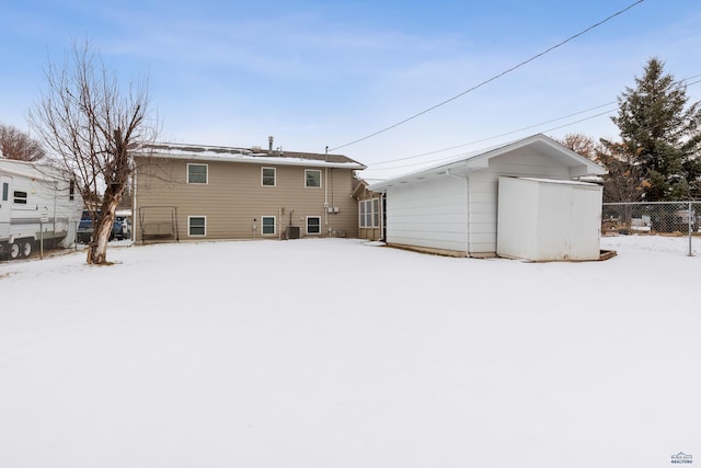 snow covered property with cooling unit