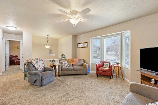 living room featuring carpet, a textured ceiling, and ceiling fan