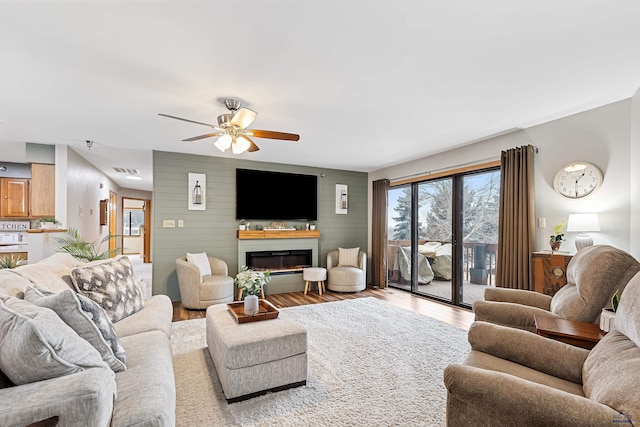 living room featuring hardwood / wood-style floors, ceiling fan, and wooden walls