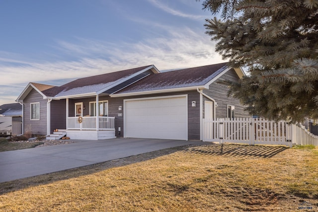 ranch-style house featuring covered porch, a front yard, and a garage