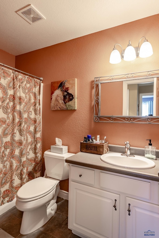 bathroom featuring vanity, tile patterned floors, a textured ceiling, and toilet