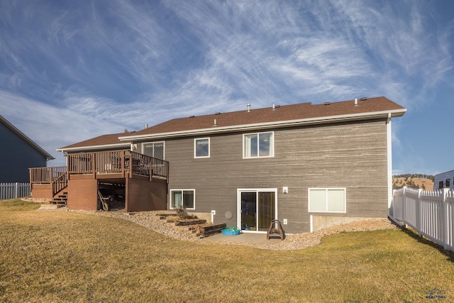 back of house with a deck and a lawn