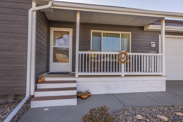 property entrance with a porch and a garage