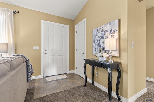 carpeted foyer with vaulted ceiling