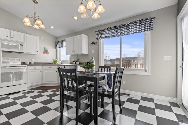 dining space with lofted ceiling, a notable chandelier, and sink