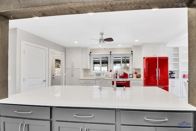 kitchen with white cabinets, refrigerator, gray cabinetry, and sink