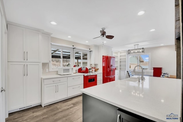 kitchen featuring sink, fridge, decorative light fixtures, and white cabinets