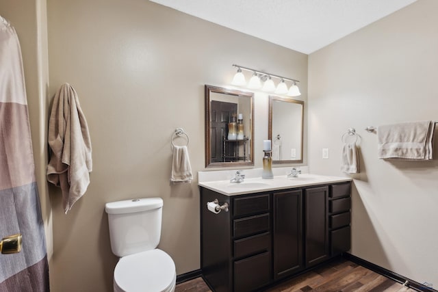 bathroom with toilet, wood-type flooring, and vanity