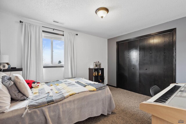 bedroom featuring a textured ceiling and carpet