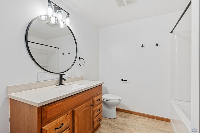 bathroom with hardwood / wood-style floors, vanity, and toilet