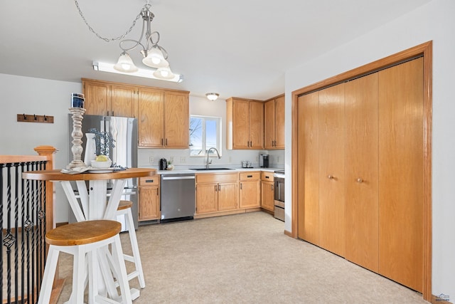 kitchen featuring appliances with stainless steel finishes, pendant lighting, a notable chandelier, and sink