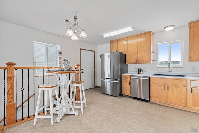 kitchen with a chandelier, decorative light fixtures, light brown cabinetry, appliances with stainless steel finishes, and sink