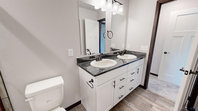 bathroom featuring toilet, vanity, and hardwood / wood-style flooring