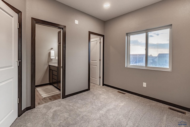 unfurnished bedroom featuring light carpet