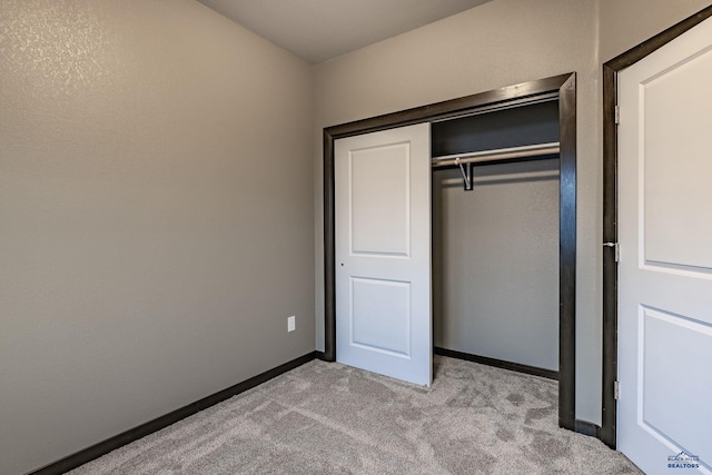 unfurnished bedroom with light carpet and a closet