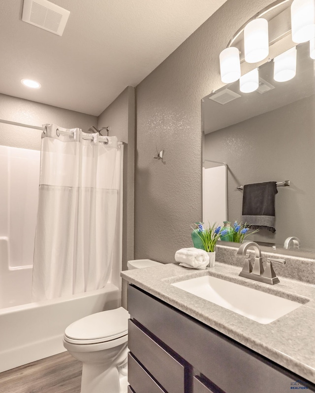 full bathroom with toilet, vanity, wood-type flooring, and shower / bath combo