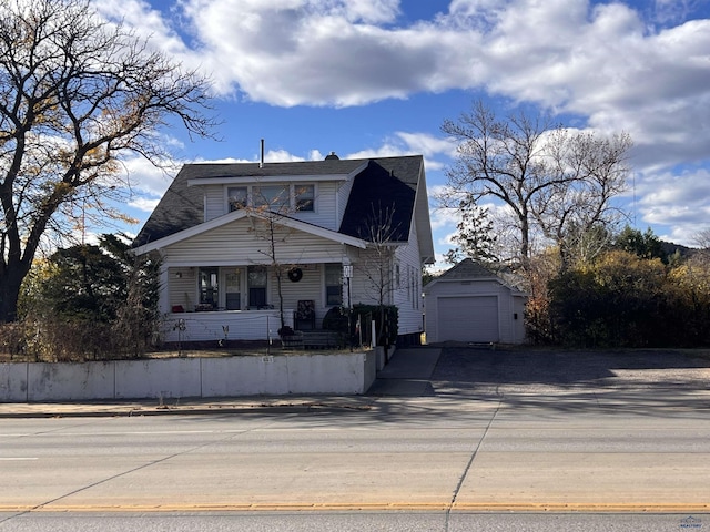 view of front of home with a garage and an outbuilding