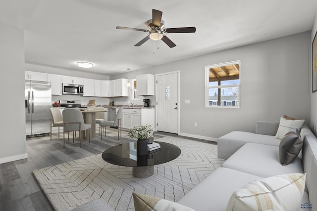 living room with ceiling fan, hardwood / wood-style flooring, and sink