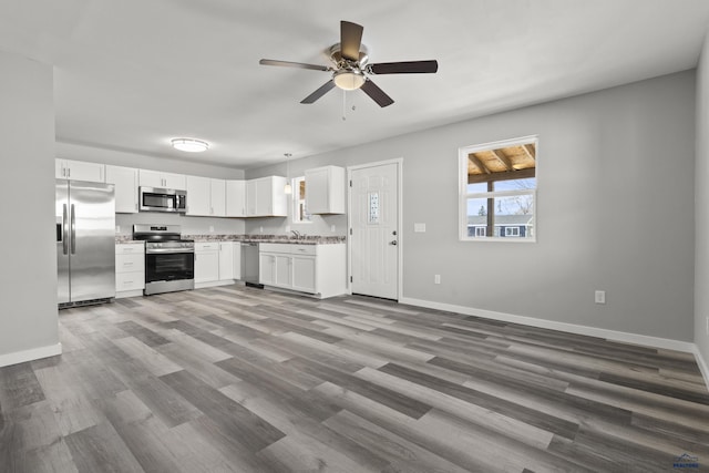 kitchen featuring white cabinets, stainless steel appliances, light hardwood / wood-style floors, sink, and ceiling fan